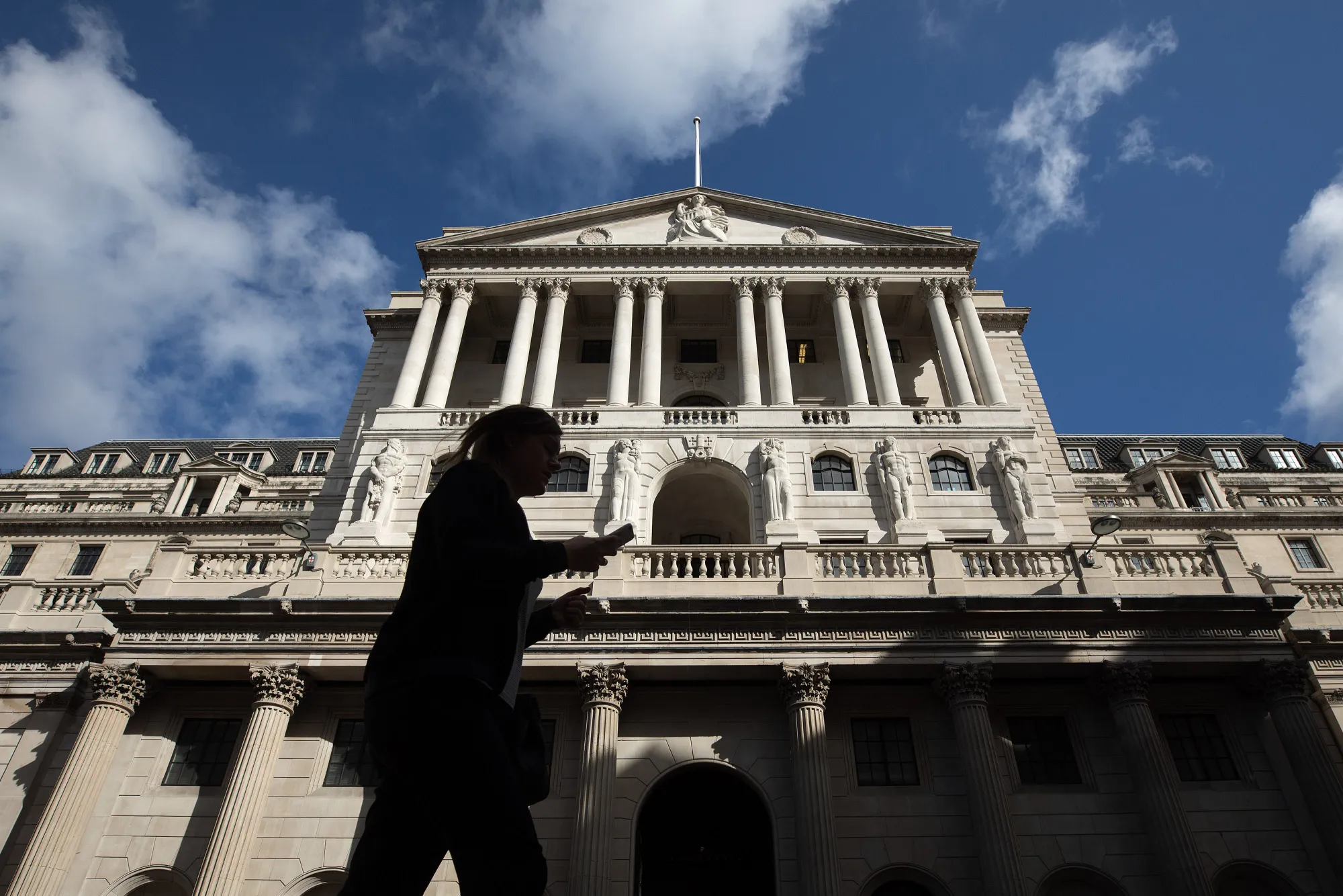 A pedestrian walks past the Bank of England in the City of London, U.K., on Monday July 31, 2017.