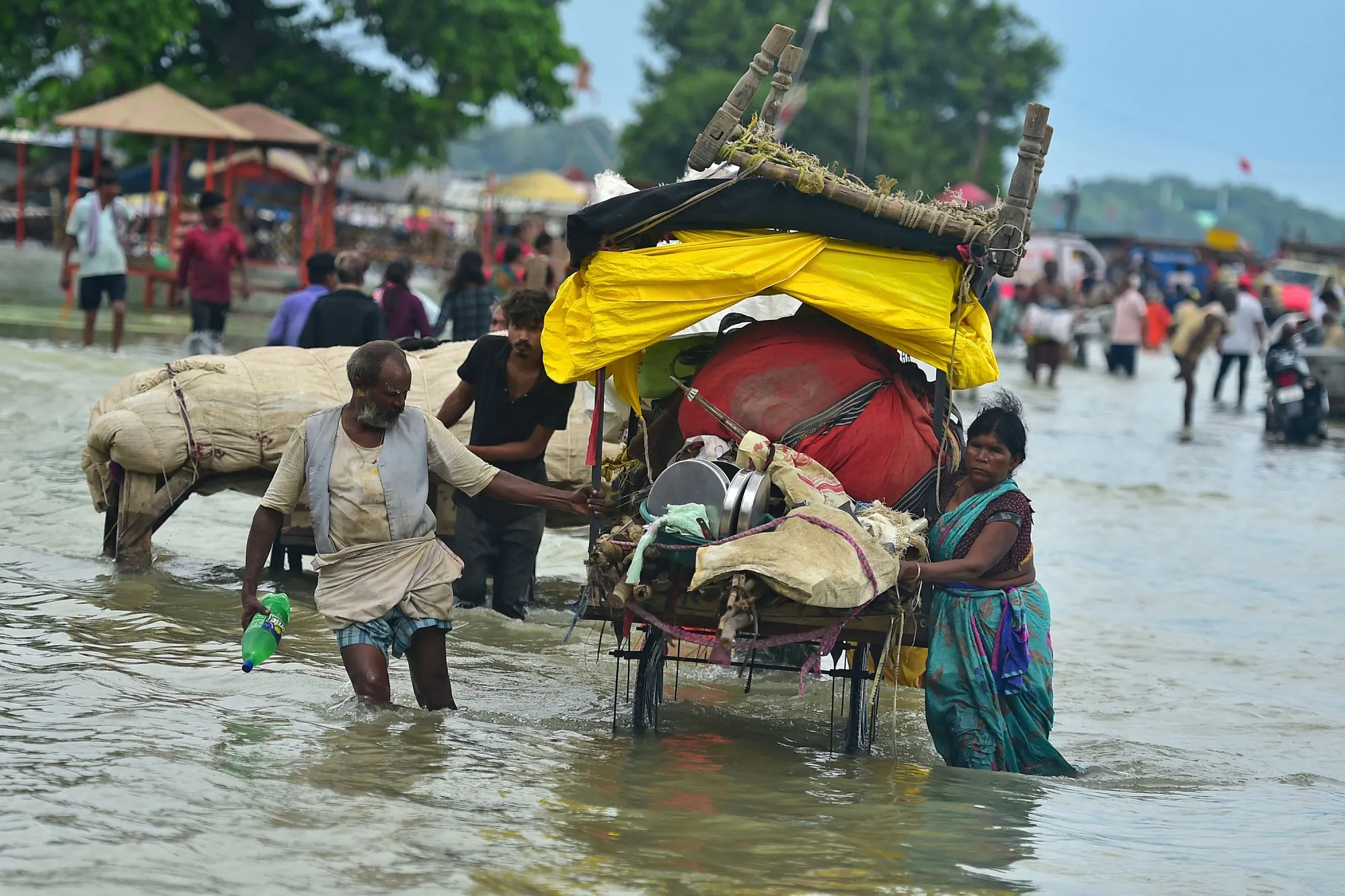 People push their belongings through flood water&nbsp;in Prayagraj, India, on Aug. 6.&nbsp;