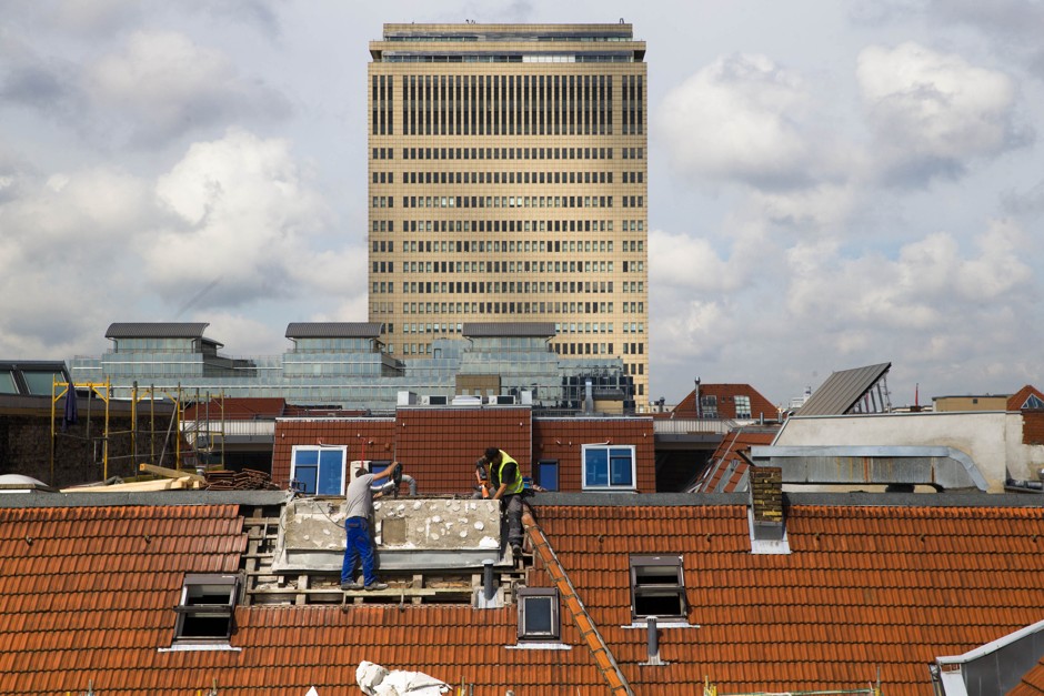 Men work on the roof of a luxury apartment building in Berlin. 