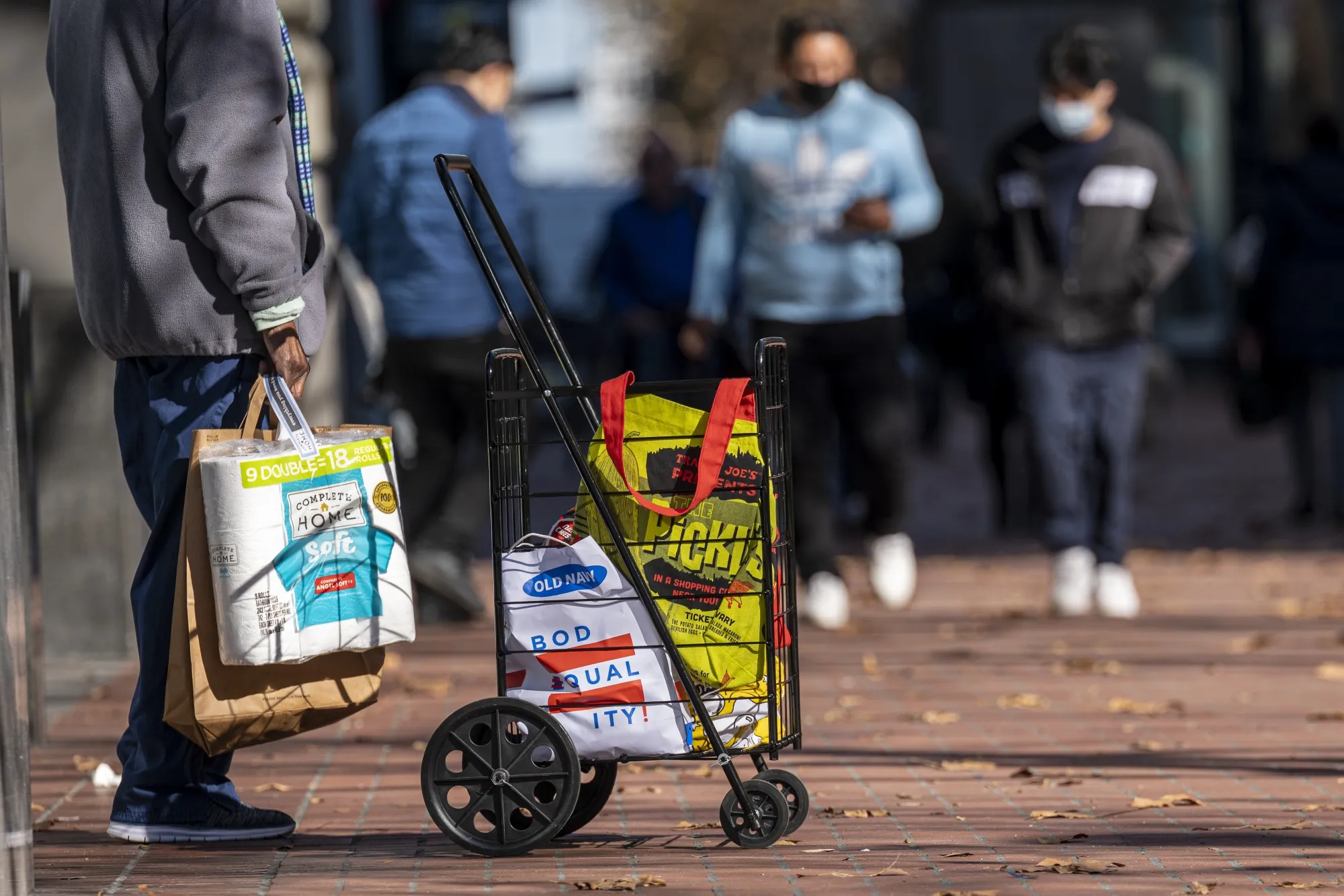 A commuter carries shopping bags on Market Street in San Francisco.