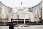 A pedestrian walks past the People's Bank of China headquarters in Beijing, China.