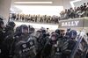 Riot police stand off against protesters inside a mall.