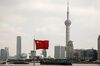 A Chinese national flag flies as skyscrapers of the Pudong Lujiazui Financial District stand across the Huangpu River in Shanghai, China, on Friday, Dec. 28, 2018. China announced plans to rein in the expansion of lending by the nation's regional banks to areas beyond their home bases, the latest step policy makers have taken to defend against financial risk in the world's second-biggest economy.