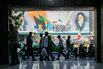 People pass a billboard depicting former Iranian supreme leaders in Tehran, on May 9.