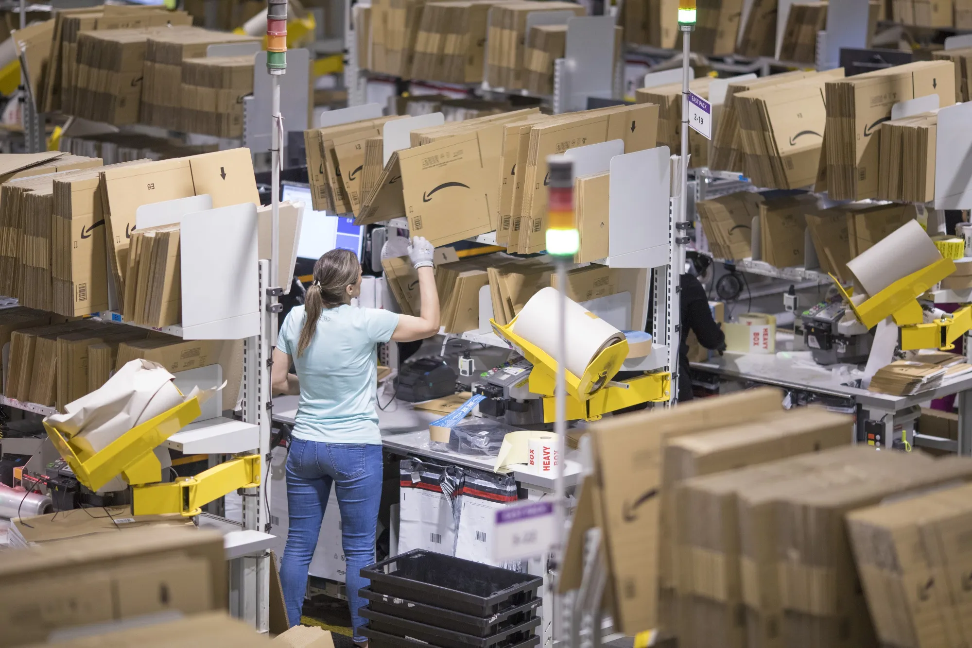 An employee packs boxes at the Amazon.com fulfilment center.
