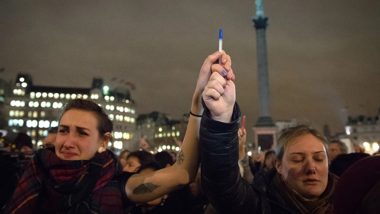 People holds pens and posters in the air as they gather in Trafalgar Square in central London to show their respect for the twelve people killed in Paris today in a terrorist attack at the headquarters of satirical publication 'Charlie Hebdo' on January 7, 2015.
