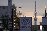 Toyota Motor Co. signage is displayed outside a dealership as the Tokyo Sky Tree stands in the background at night in Tokyo, Japan, on Sunday, May 10, 2020.