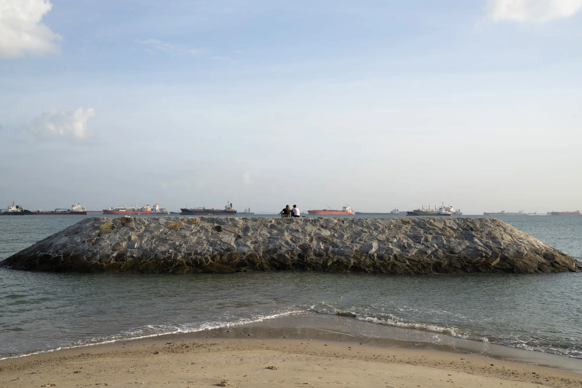People look out to sea from&nbsp;a breakwater at East Coast Park, a stretch of&nbsp;reclaimed land along the southeastern coast of&nbsp;Singapore.