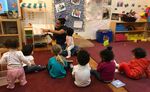 A daycare provider reads to students in New York City.