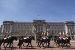 Mounted soldiers pass Buckingham Palace in London.