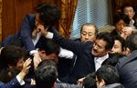 Japanese ruling and opposition lawmakers scuffle at the Upper House's ad hoc committee session for the controversial security bills at the National Diet in Tokyo on Thursday.
