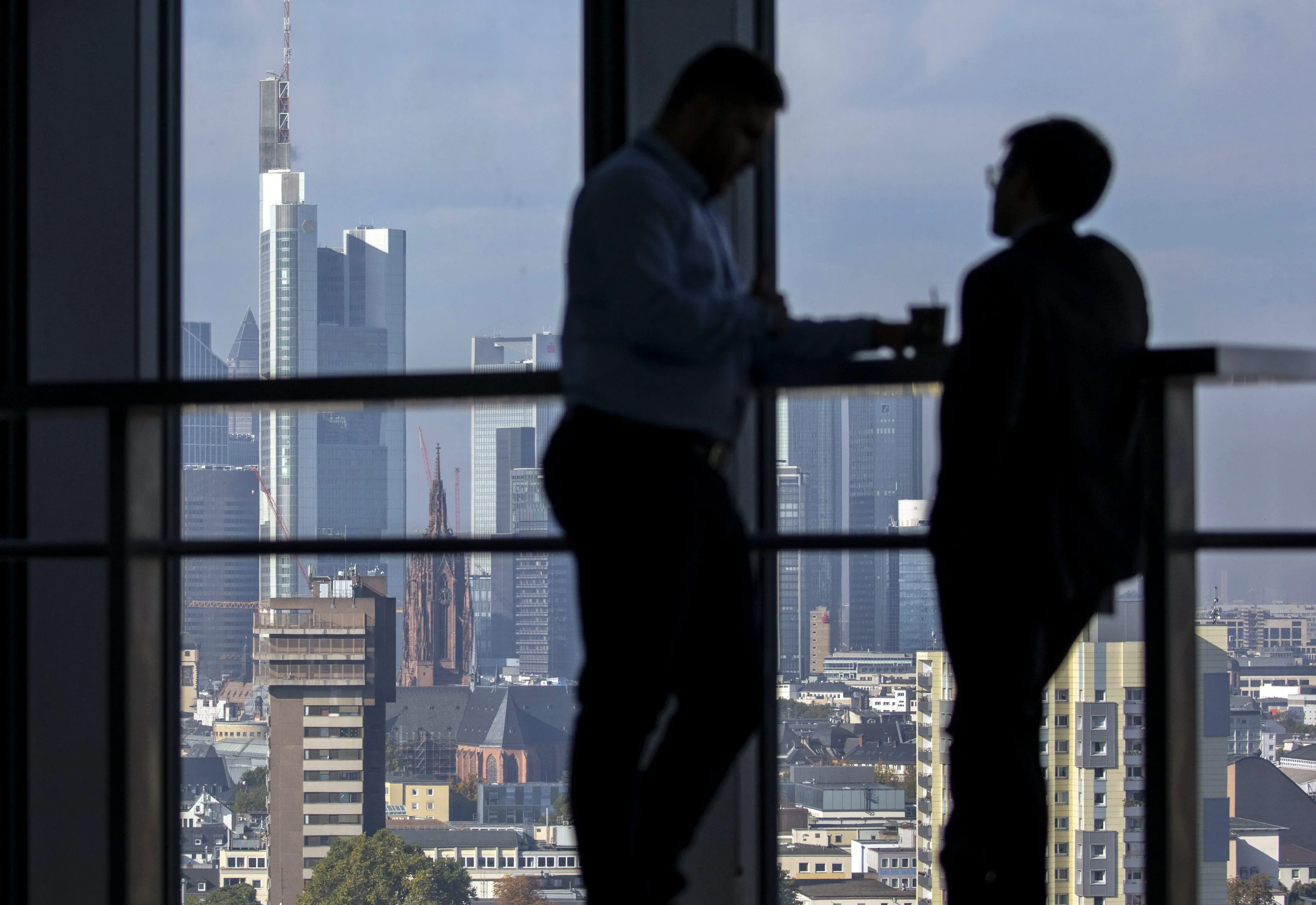 Visitors talk as skyscrapers tower over commercial and residential property on the city skyline as seen from the 15th floor pantry area inside the European Central Bank (ECB) headquarters in Frankfurt, Germany, on Wednesday, Oct. 18, 2017. In a tweet with the hashtag #Brexit, Goldman Sachs Group Inc. Chief Executive Officer Lloyd Blankfein on Thursday hailed “great meetings” he had in Frankfurt and said he will spend a lot more time there.
