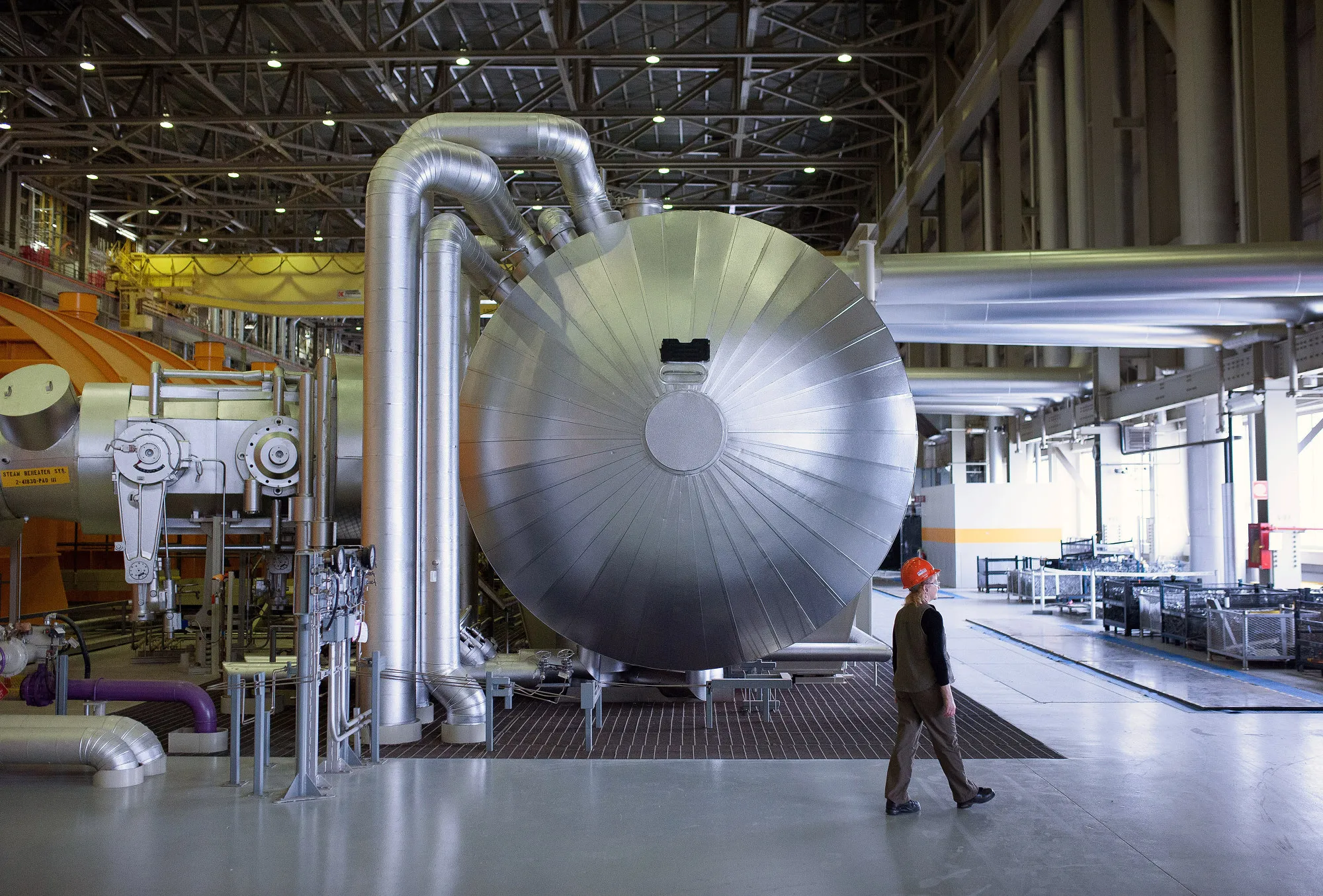 An employee walks past a steam condenser at a nuclear power generating station in Bowmanville, Ontario.