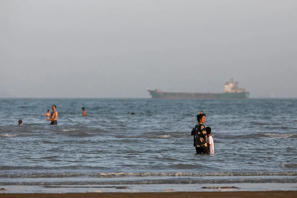 Iranians take a dip in the Persian Gulf amid pleasant weather off Bandar Abbas, Iran. The environment for global inflation and bond yields has become considerably less pleasant.