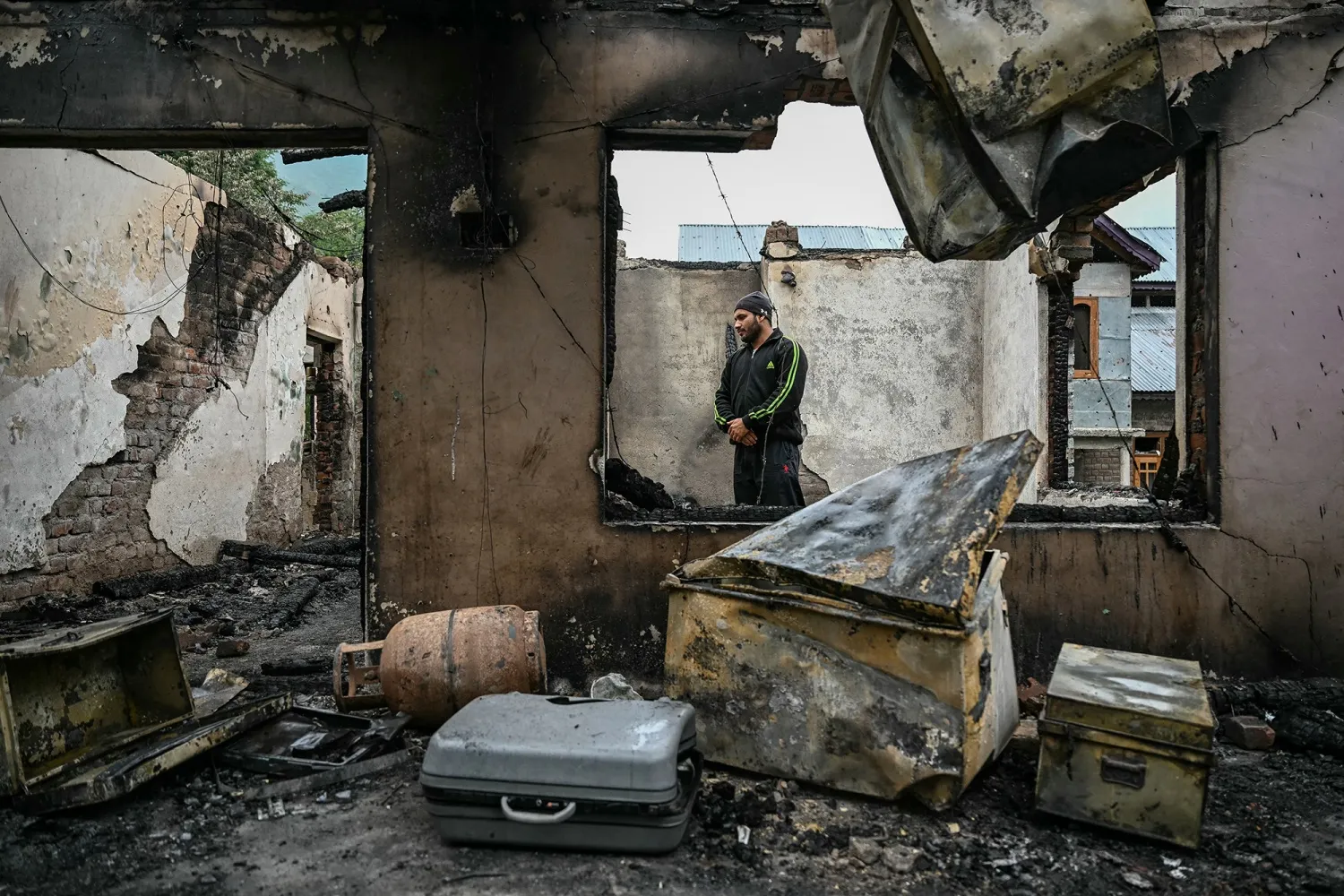 A resident stands inside their house destroyed by Pakistani artillery shelling at the Salamabad village in Uri,&nbsp;on May 8.