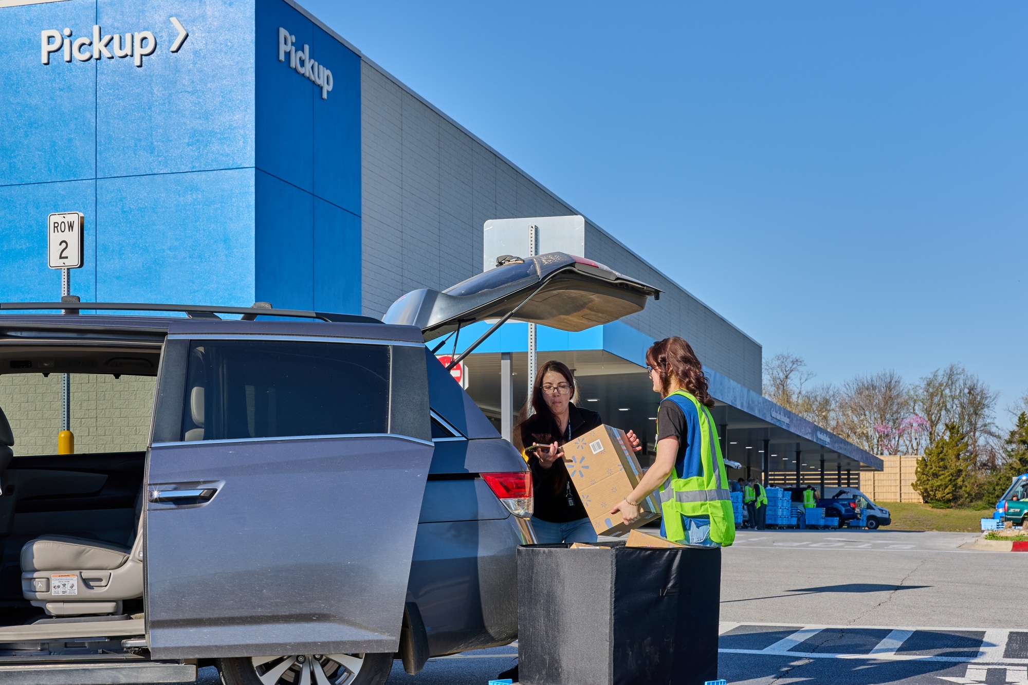 A customer loads their van with online delivery orders with the help from a store associate, at Walmart in Bentonville, Arkansas. Photographer: Melyssa St. Michael/Bloomberg