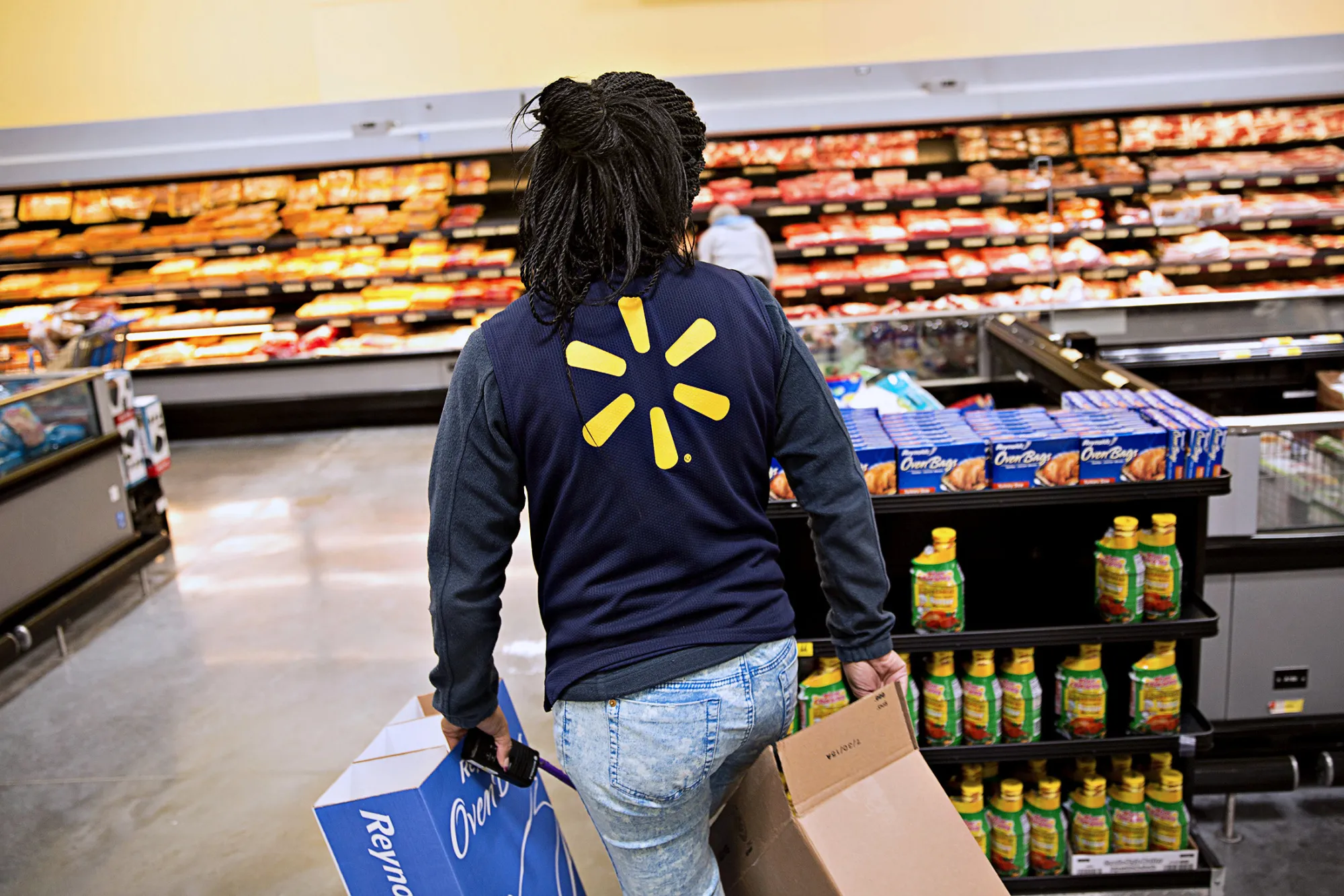 An employee carries empty boxes after restocking items at a Wal-Mart Stores Inc. location in Chicago, Illinois, U.S., on Wednesday, Nov. 25, 2015. In 2011, several big U.S. retailers moved their opening times to midnight; in 2012, Wal-Mart crossed the Rubicon and opened its stores at 8 p.m. on Thanksgiving Day. But after last year's Thanksgiving weekend retail sales fell 11 percent from the year before while overall holiday sales rose, some retailers have been reconsidering.
