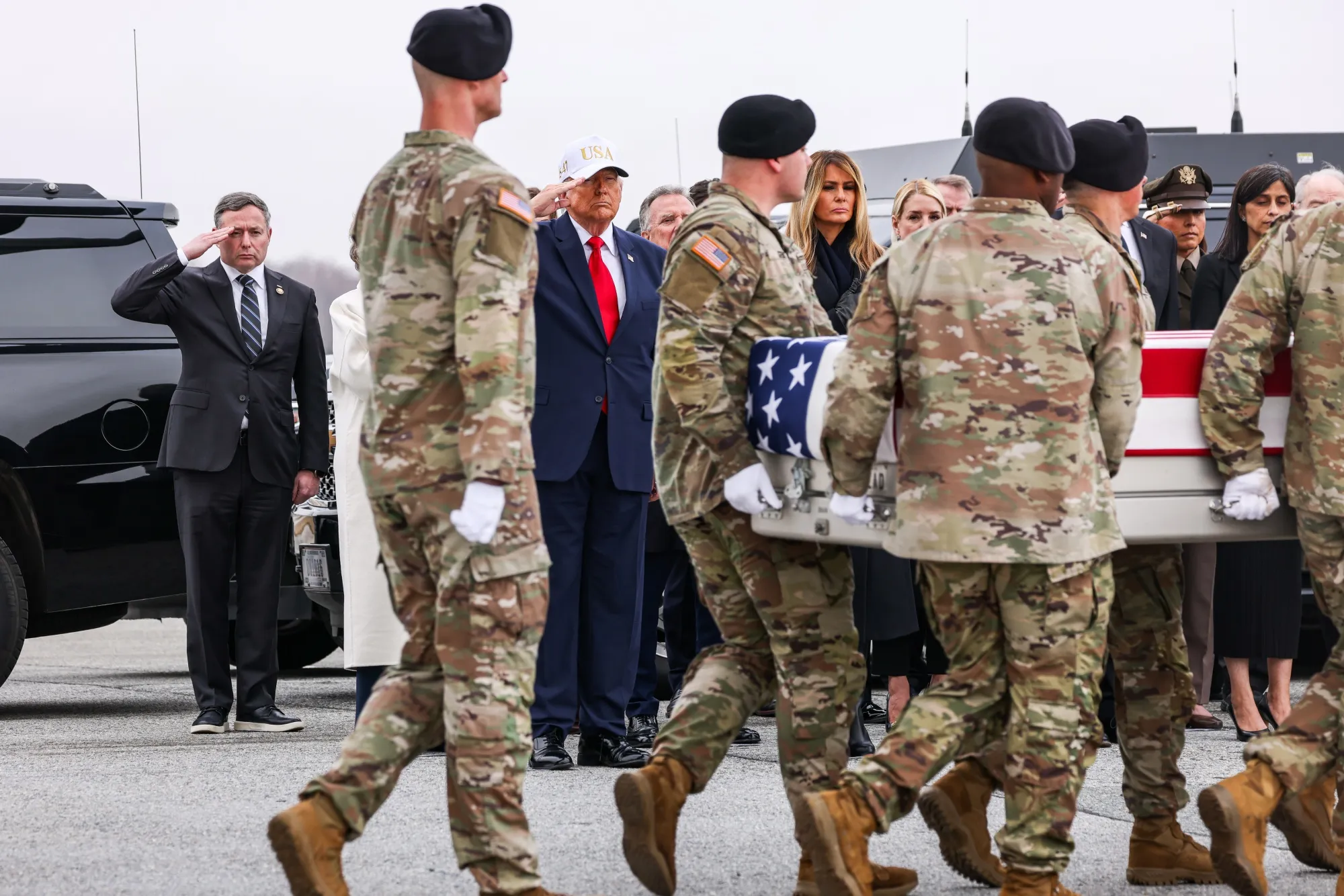 US President Donald Trump, center, salutes during a dignified transfer at Dover Air Force Base in Dover, Delaware, on Saturday, March 7, 2026.