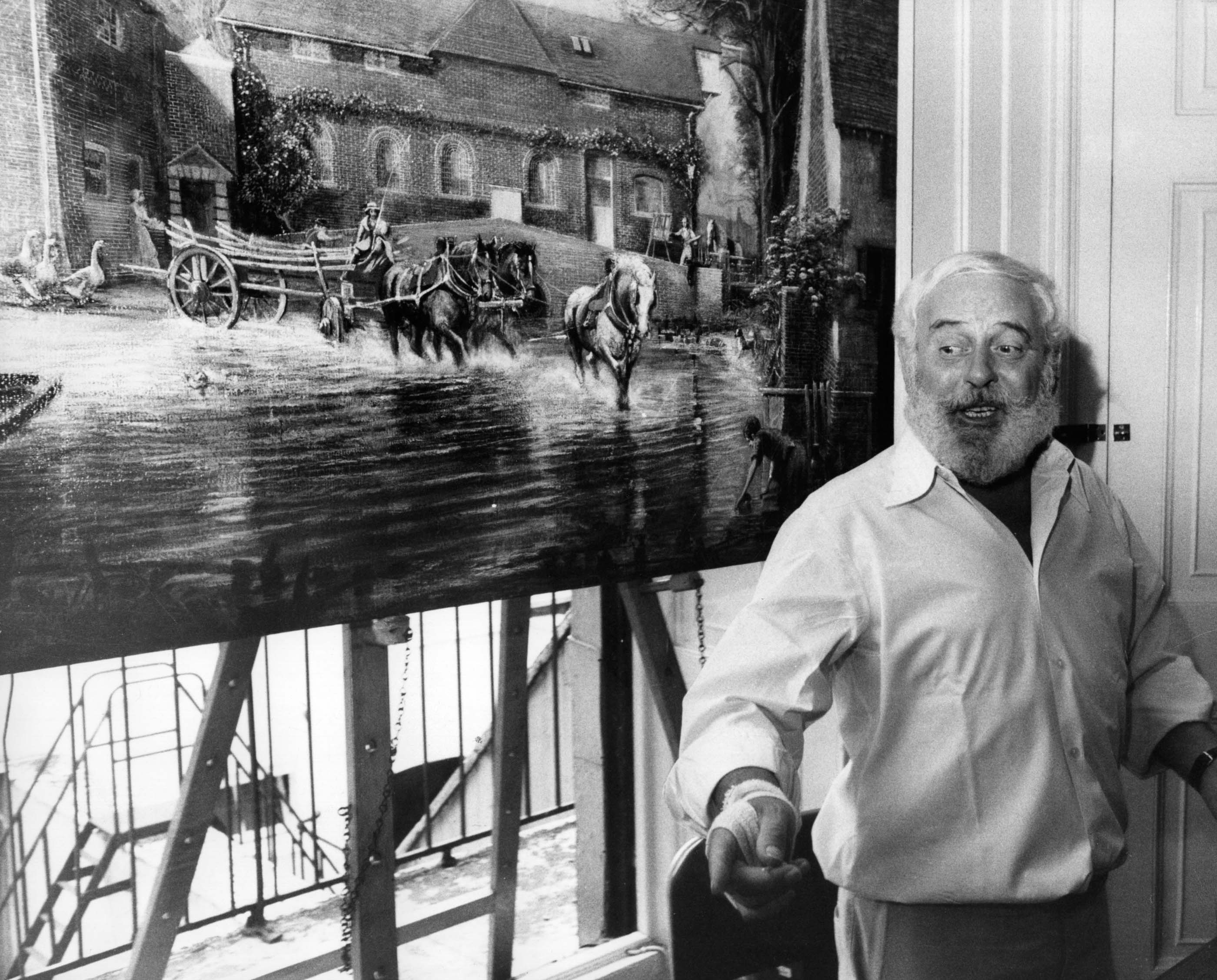 27th August 1976: Tom Keating (1917 - 1984) the art restorer and master forger standing by his fake painting of Constable's 'Hay Wain'. (Photo by Keystone/Getty Images) Photographer: Keystone/Getty Images