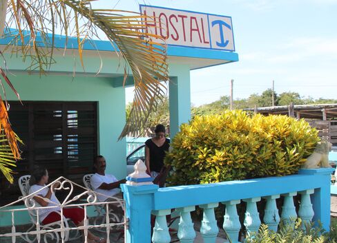 Carlos Jimenez sits on Playa Giron guesthouse's porch with his wife. Photographer: Andrew Willis/Bloomberg