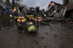 Rescue workers carry away the body of a victim of flash flooding triggered by rain filling up nearby streams that burst their containment mechanisms, collapsing a hillside and bringing waves of mud over homes in La Gasca area of Quito, Ecuador, Tuesday, Feb. 1, 2022. (AP Photo/Dolores Ochoa)