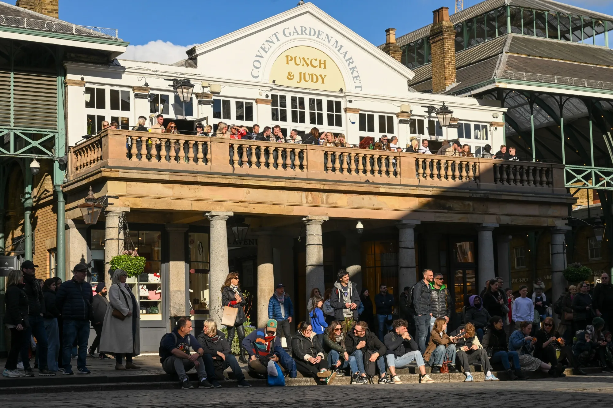 Tourists watch a street performer in the Covent Garden district of London.