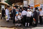 Ultra-Orthodox Jewish men and boys stand along a street corner in the Mea Shearim neighbourhood in Jerusalem.