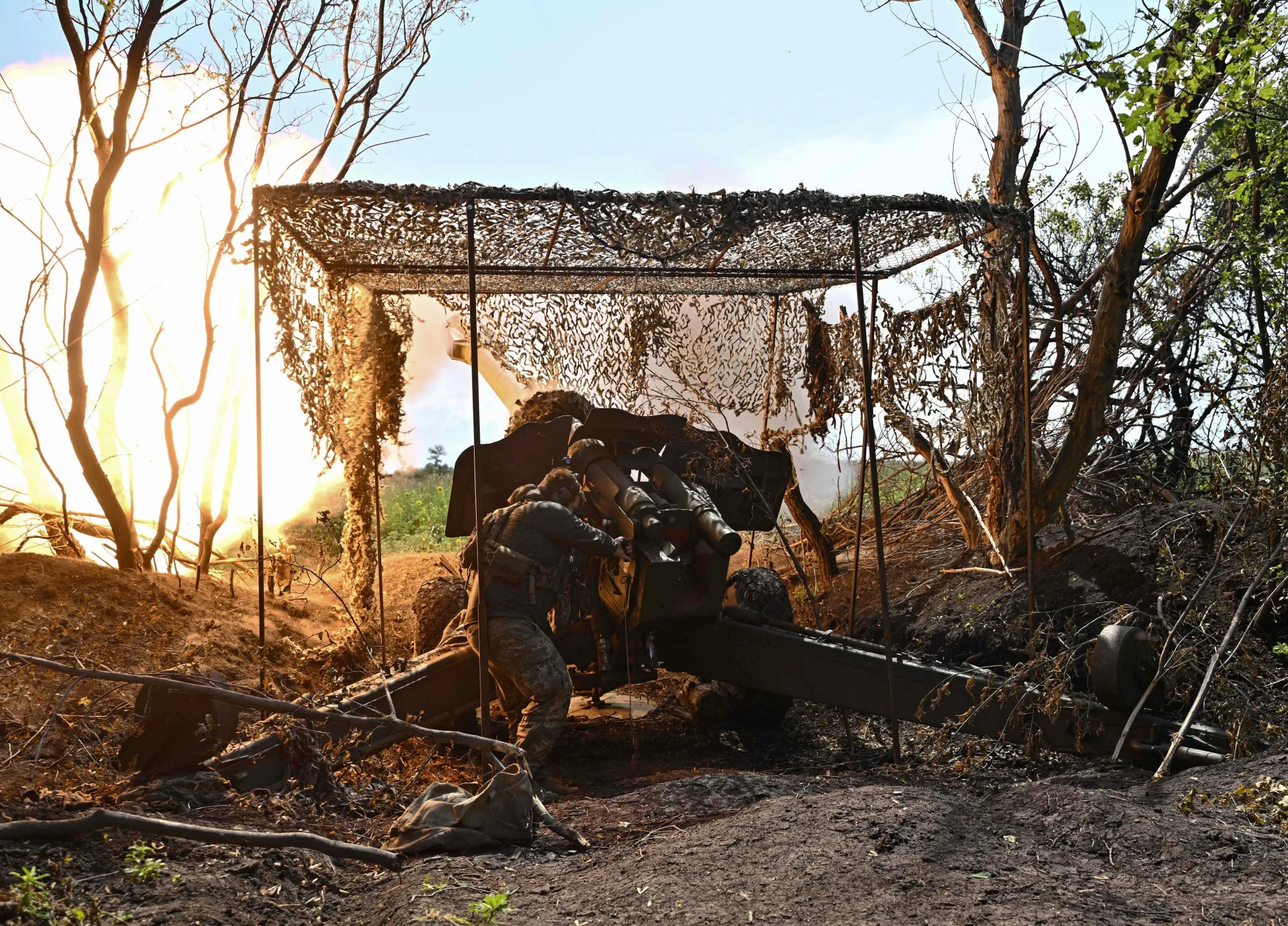 A Ukrainian artilleryman fires a 152 mm towed gun-howitzer D-20 at Russian positions.