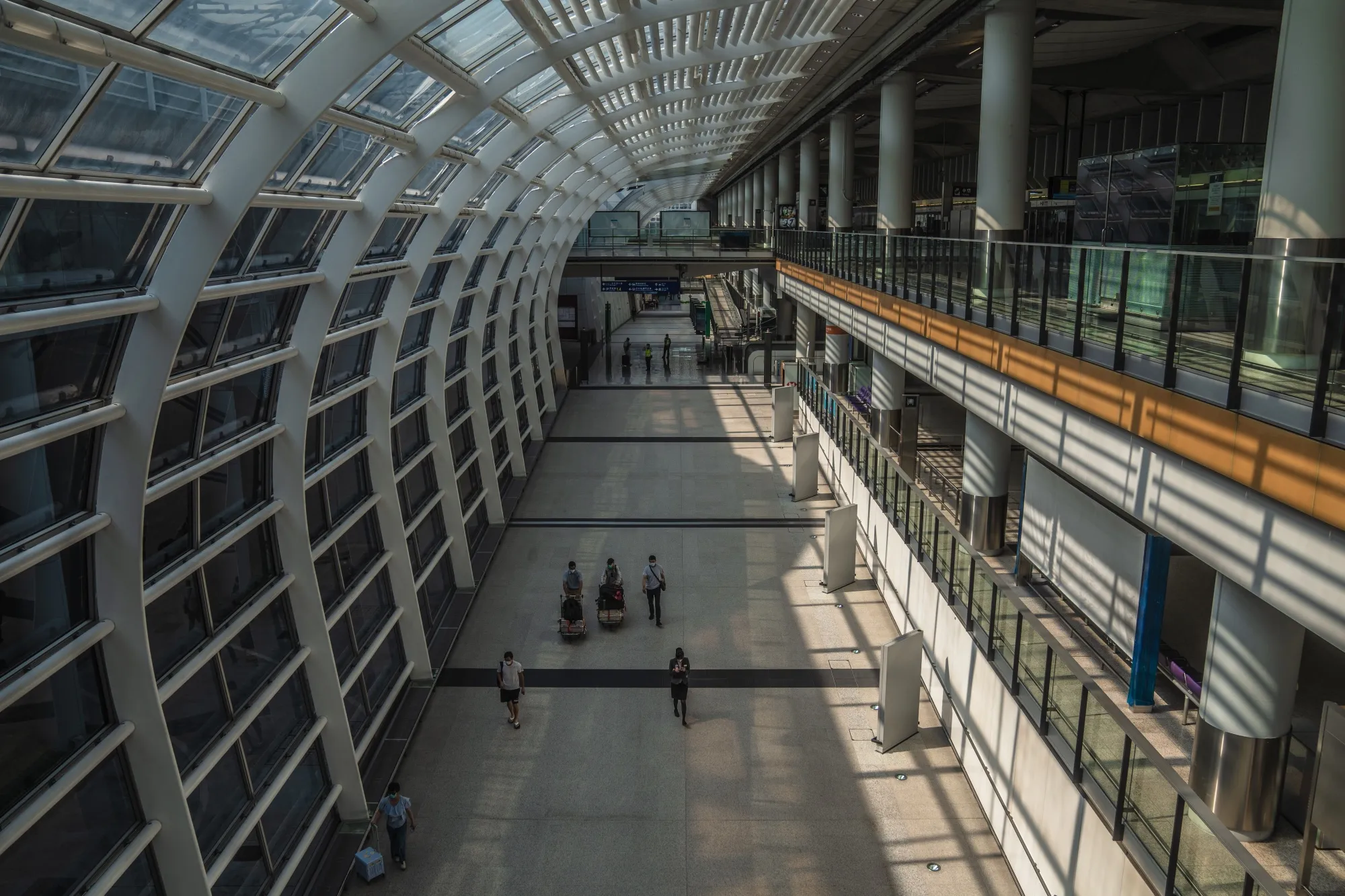 Travelers walk through Hong Kong International Airport following the government's scrapping of its hotel quarantine&nbsp;regime