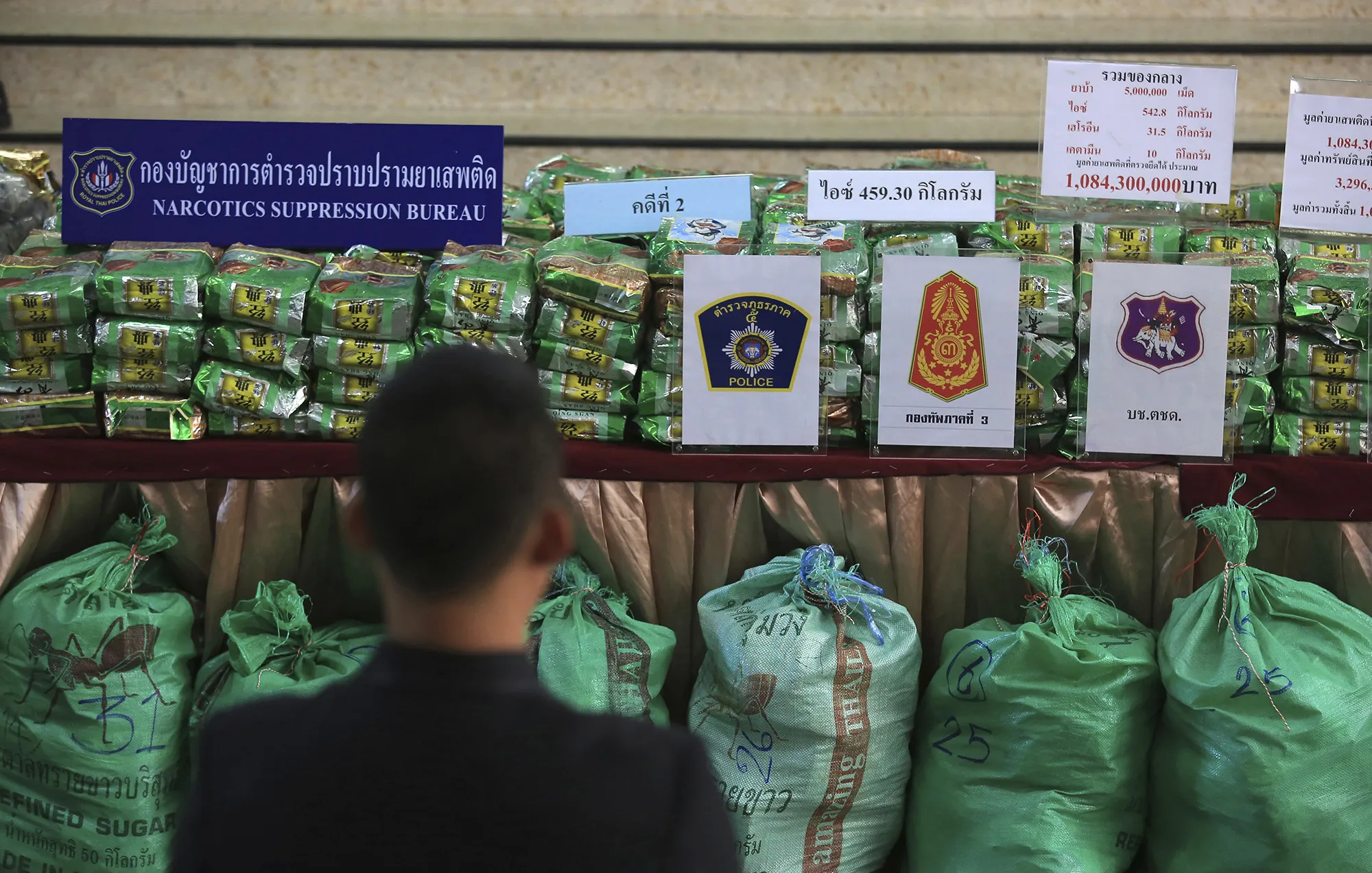 A reporter views packages of seized 459 kilograms (1,012 pounds) of crystal methamphetamine on a table during a press conference at the Narcotics Suppression Bureau Bangkok on July 15, 2019.&nbsp;