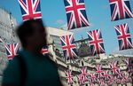A pedestrian walks underneath rows British Union flags suspended above Regent Street in London, U.K., on Tuesday, May 24, 2016. U.K. retail sales began the second quarter with more momentum than economists forecast.
