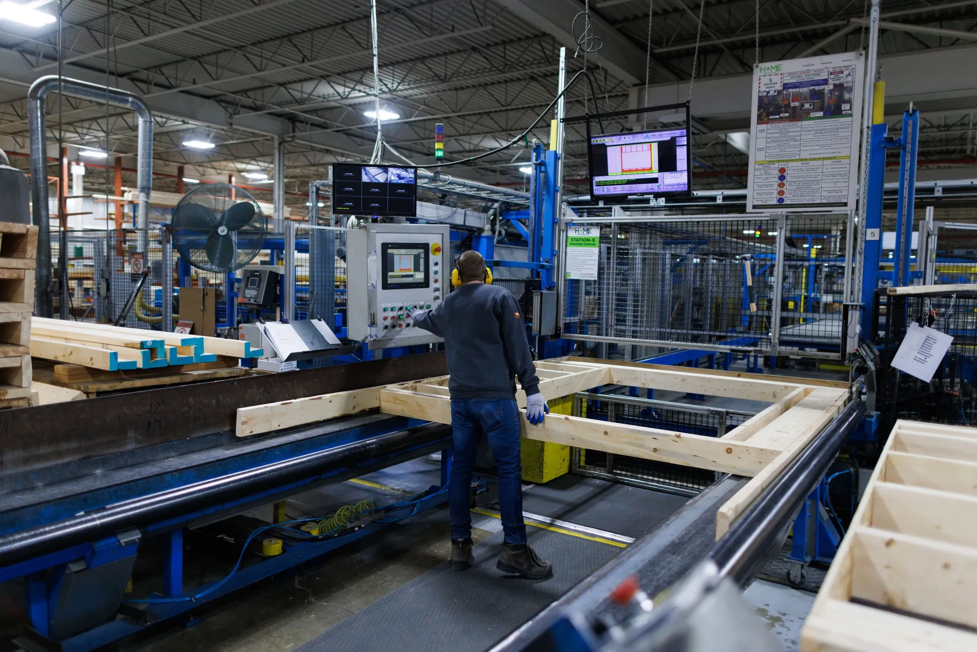 A worker monitors a machine making wall panels at a Toronto factory.