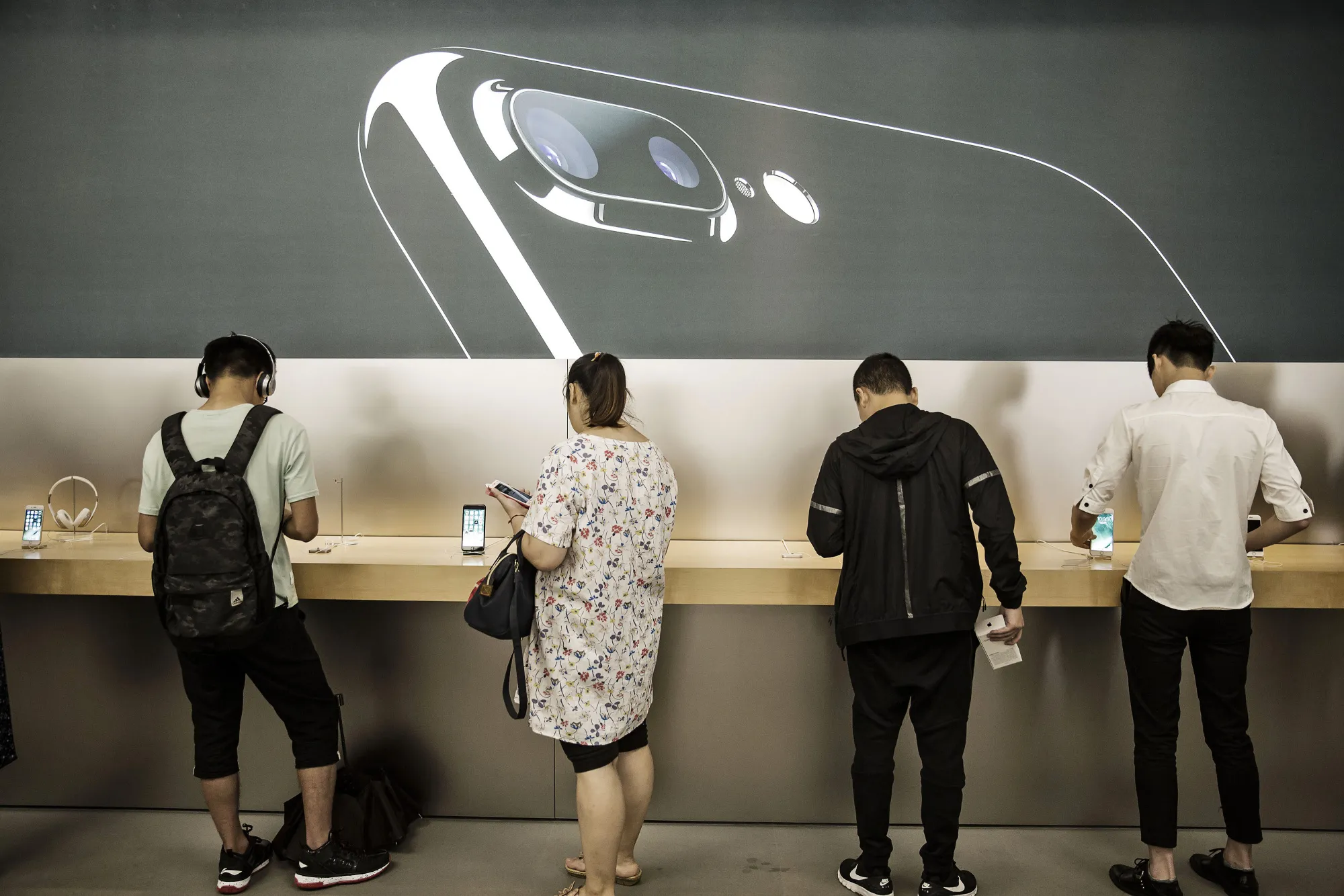 Customers look at the Apple products at a store in Shanghai.