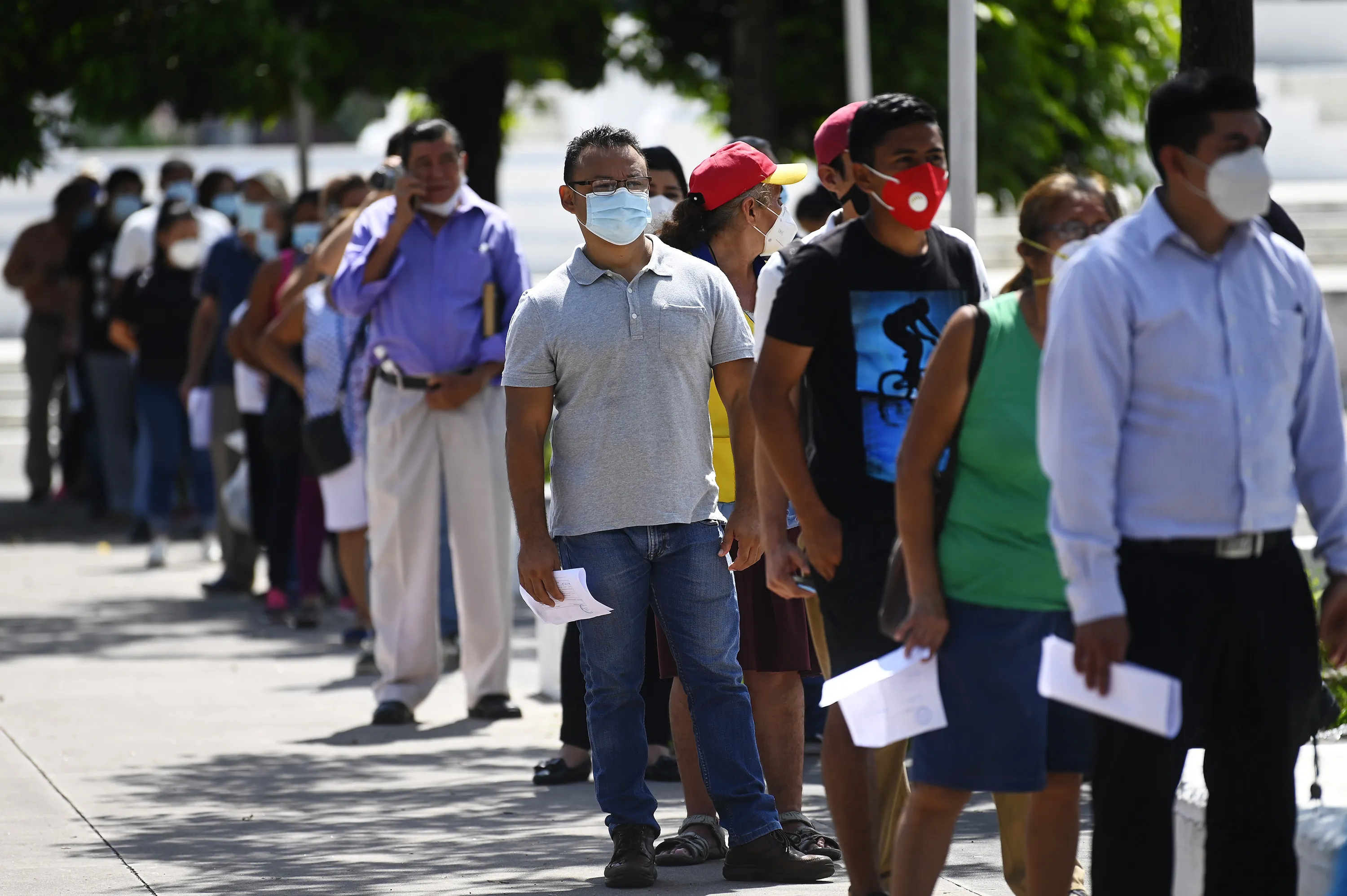 People queue maintaining physical safe distance to get a free COVID-19 test at a diagnostic booth&nbsp;in San Salvado.