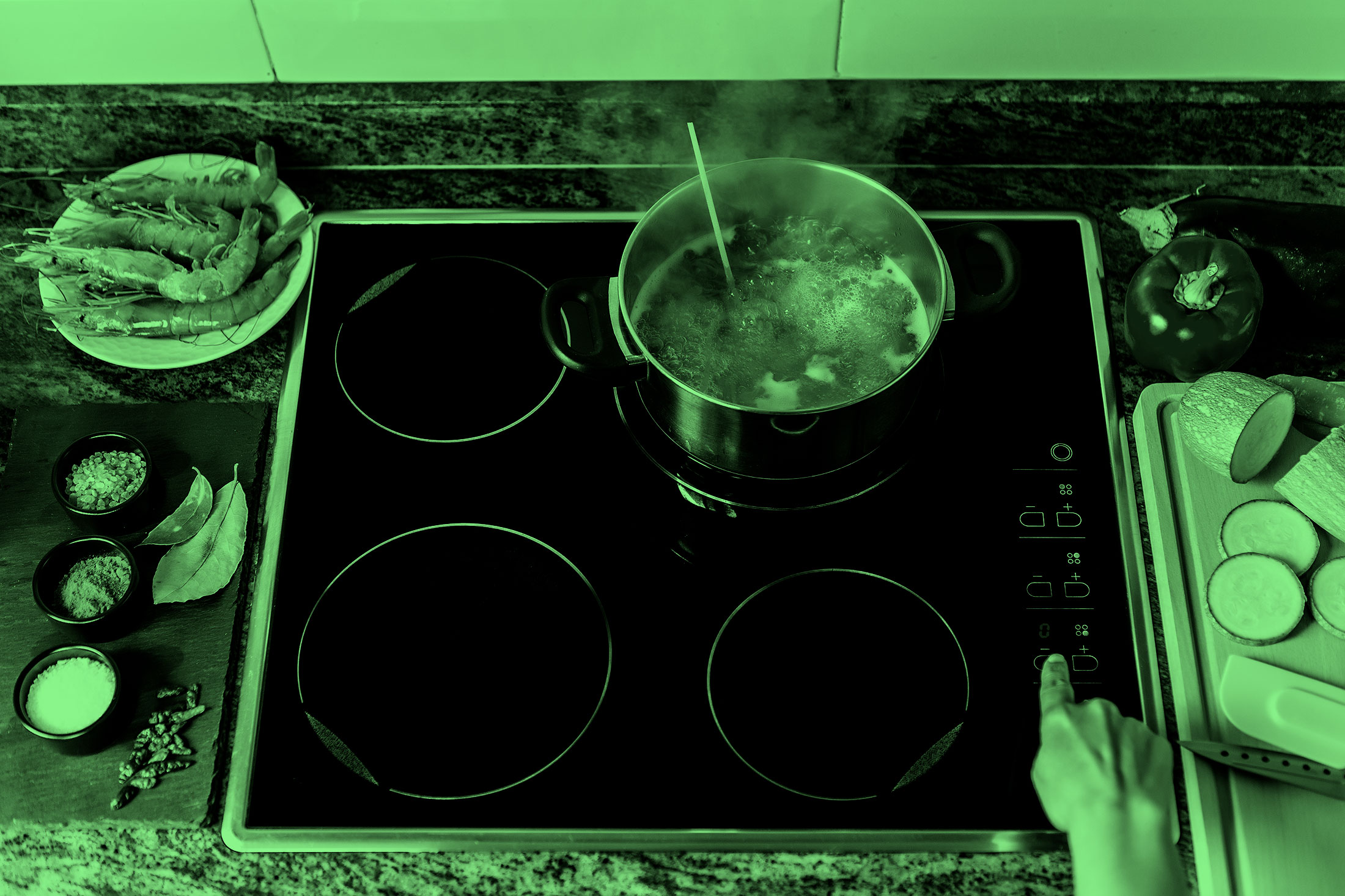 From above someone touching a button on induction cooktop while cooking dinner in modern home kitchen, on an induction stove