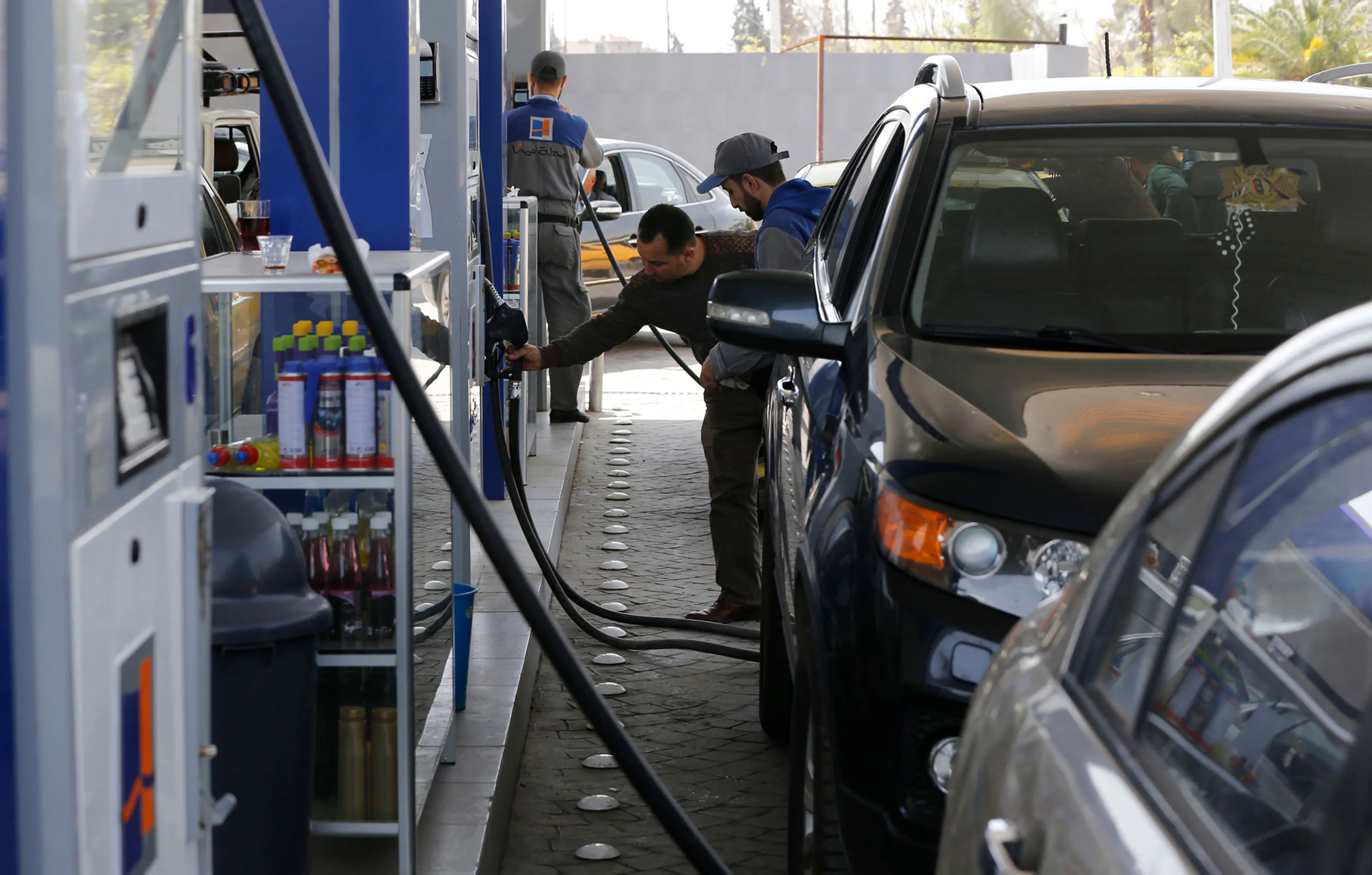 Syrians queue to fill their car with gasoline at a station in Damascus.&nbsp;