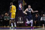 Dallas Mavericks' Luka Doncic (77) smiles after making a basket against Los Angeles Lakers' LeBron James (6) during the first half of an NBA basketball game Thursday, Jan. 12, 2023, in Los Angeles. (AP Photo/Jae C. Hong)