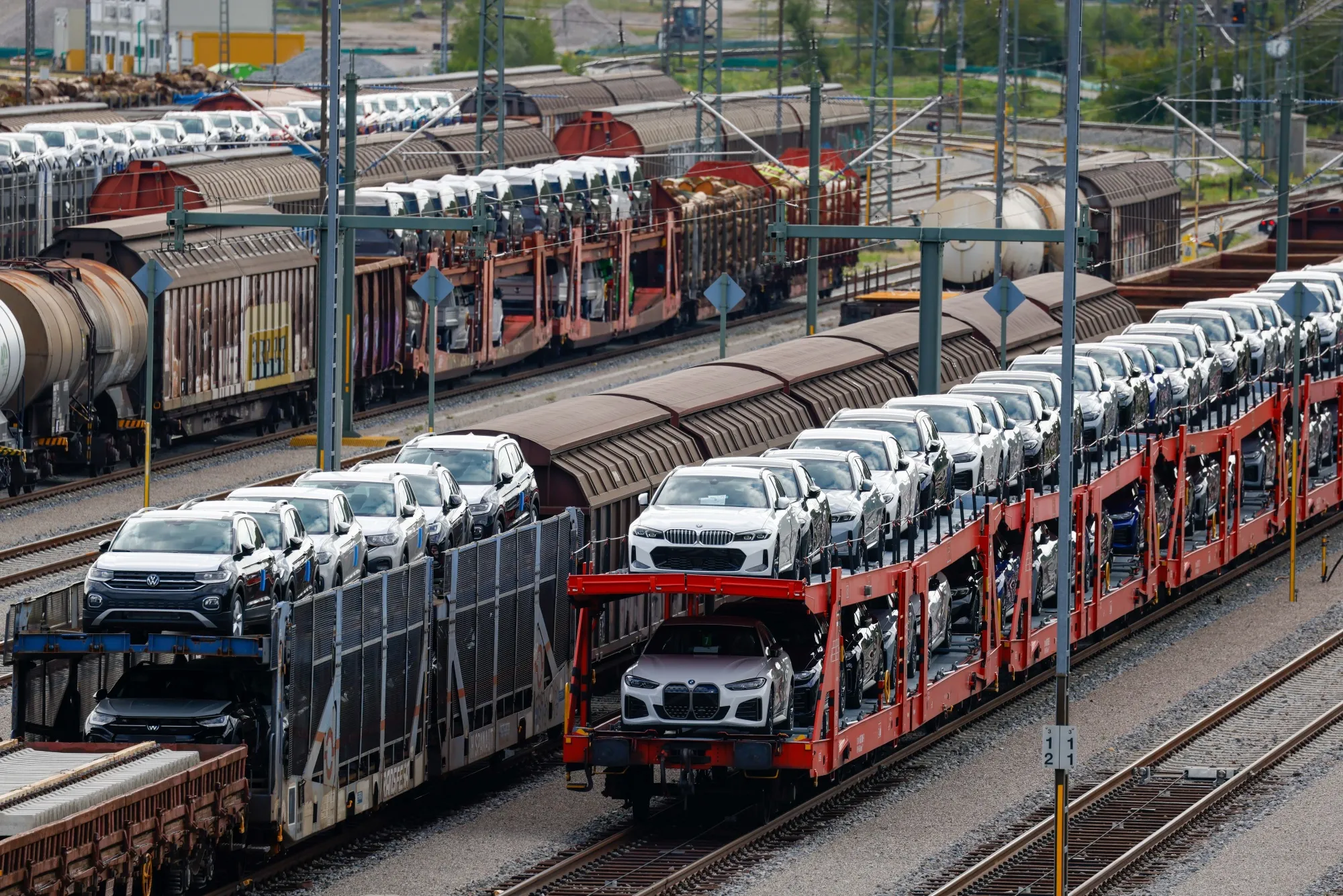 Freight wagons, loaded with newly manufactured Volkswagen AG and BMW AG automobiles, at a railway yard in Munich, Germany.