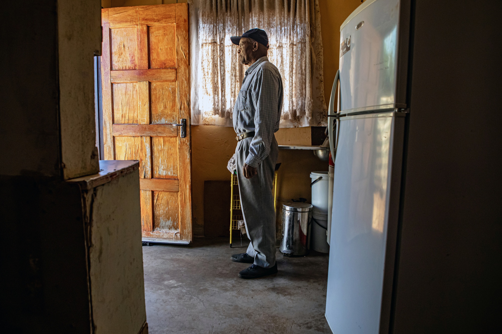 Frans Baloyi, now in his 70s, stands in his first-ever home.