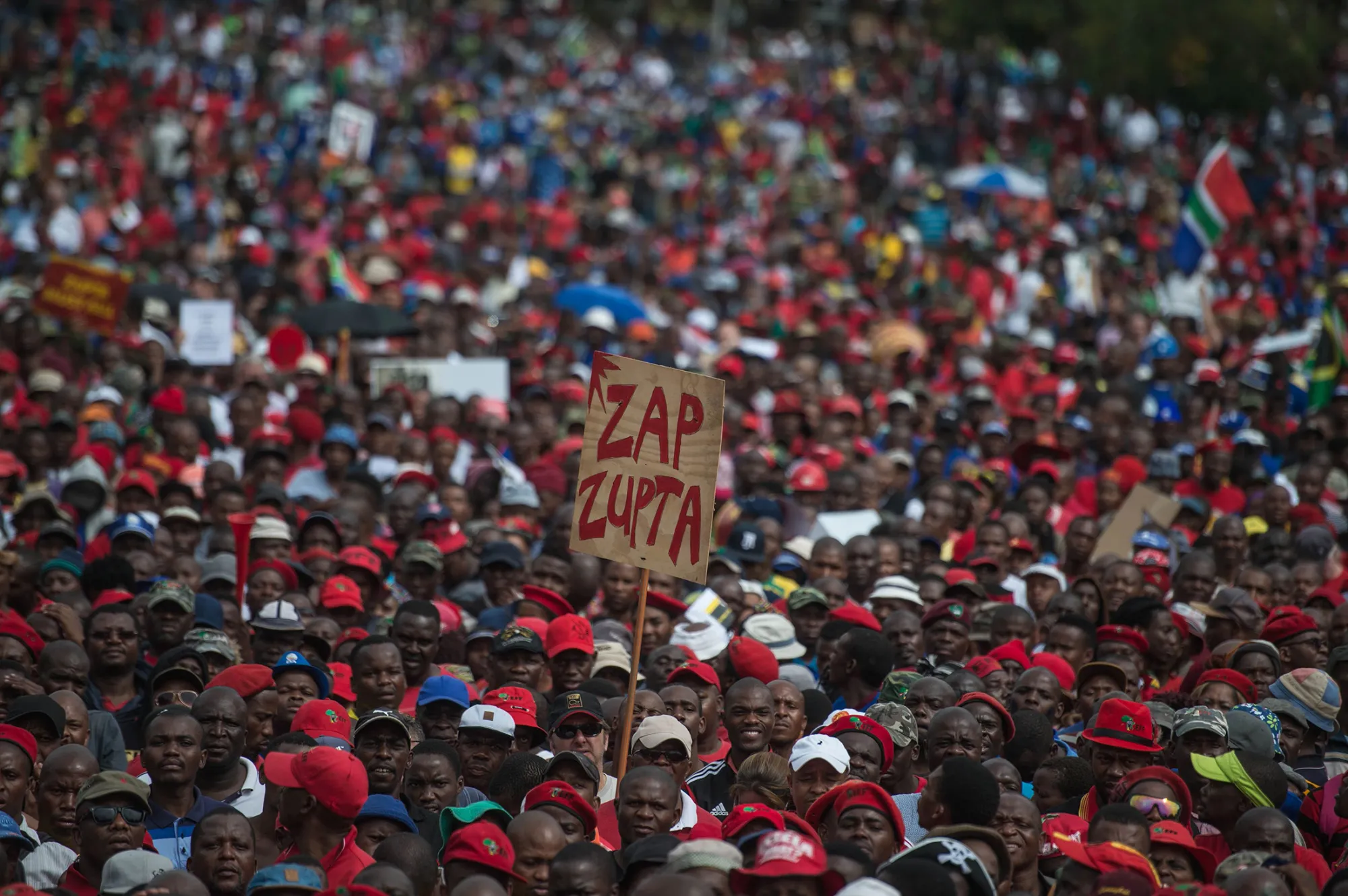 A protester holds a placard reading 'Zap Zupta', referring to Zuma and the Gupta Family, in Pretoria on April 12, 2017.
