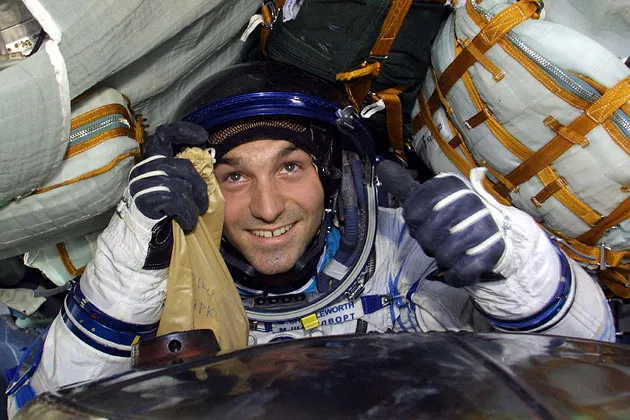 As the world's second space tourist, Shuttleworth grins inside a Soyuz capsule after landing in Kazakhstan in 2002