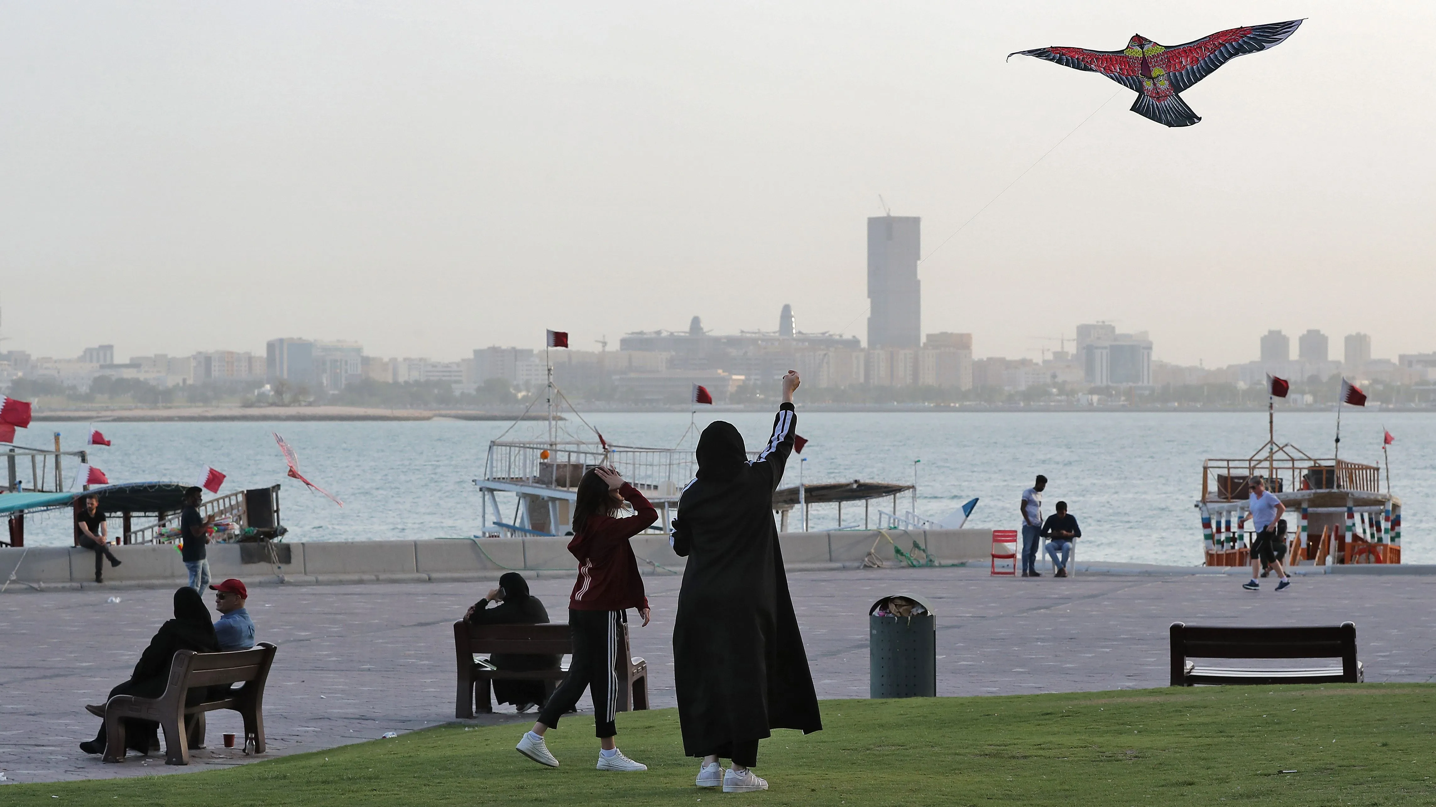 A girl and a woman fly a kite along the promenade by the Doha corniche in the Qatari capital on March 16.