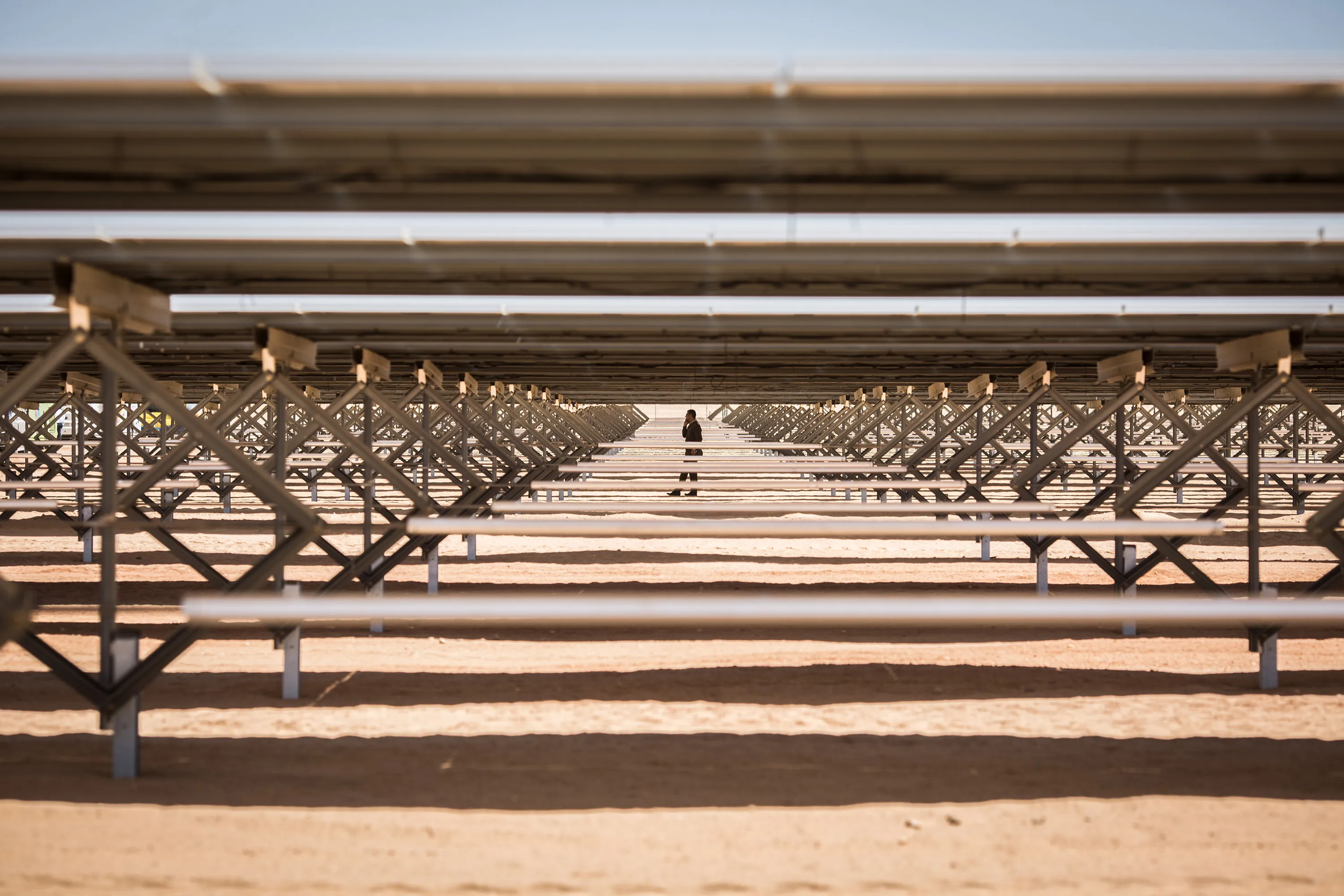 A worker walks amidst solar panels at the Infinity 50 Solar Park near Aswan, southern Egypt.