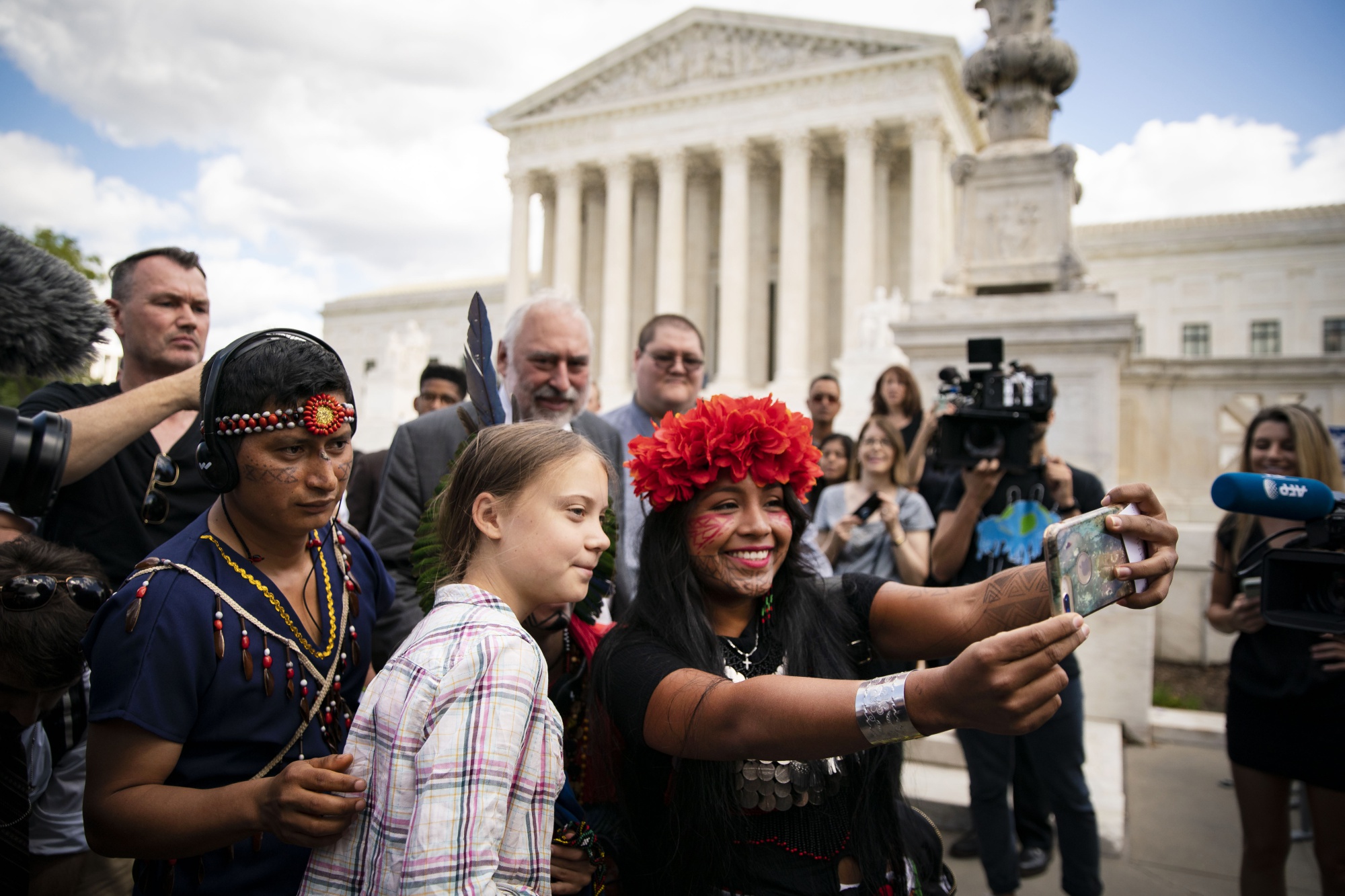 Militza Flaco, a climate activist from Panama, right, uses a mobile device to take a 'selfie' photograph with Swedish activist Greta Thunberg, center, outside the Supreme Court in Washington, D.C., U.S., on Wednesday, Sept. 18, 2019.
