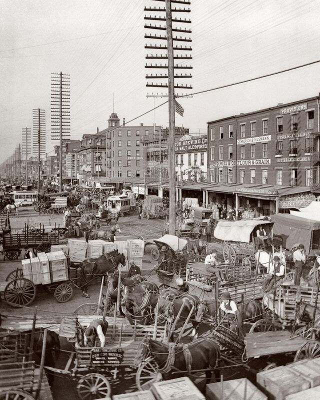 ■ *** LOW RES *** Commercial horse wagons next to a line of electricity utility poles in West Street, New York, around 1880.