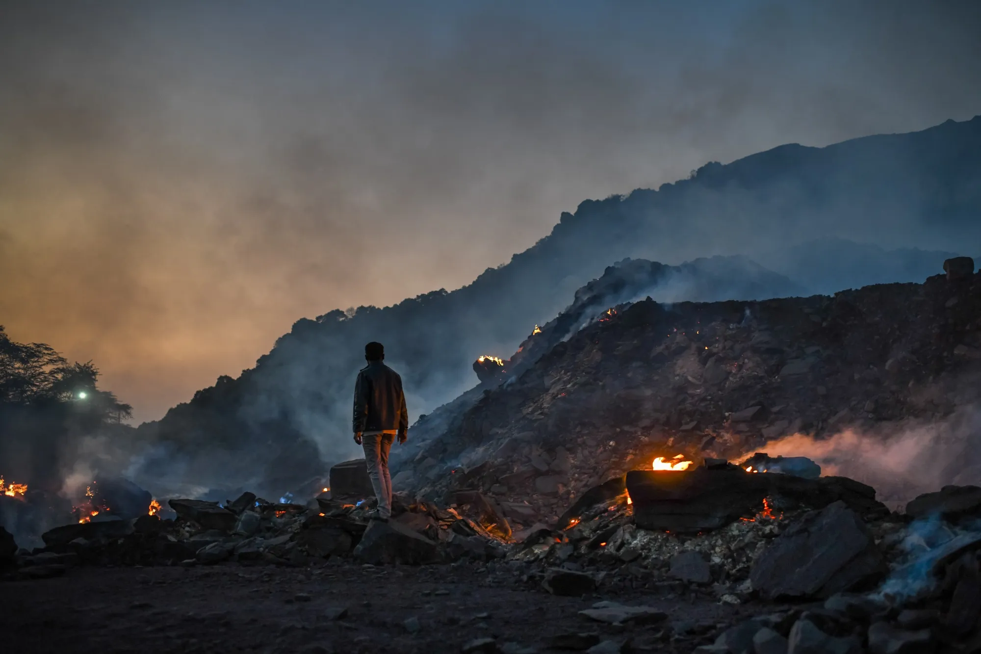 A man stands near burning coal waste&nbsp;in Uttar Pradesh, India.