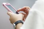 A woman uses her smartphone in Tokyo, Japan, on Monday, June 30, 2014.