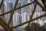 Residential buildings seen through a construction crane stand in the West Kowloon district of Hong Kong, China, on Friday, Jan. 9, 2015. Hong Kong home prices surged to a record last year, making Chief Executive Leung Chun-ying's task of addressing the city's affordability crisis even harder.
