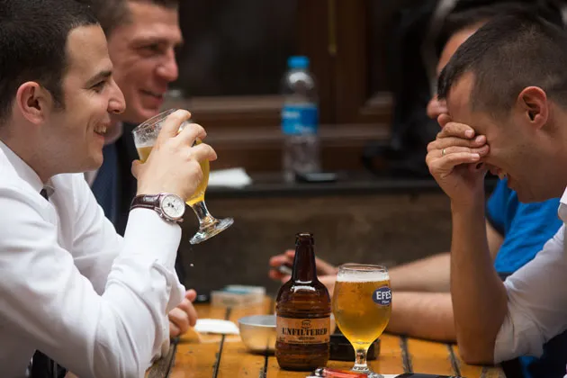 Customers drink beer from Efes-branded glasses in a bar near Taksim Square in Istanbul