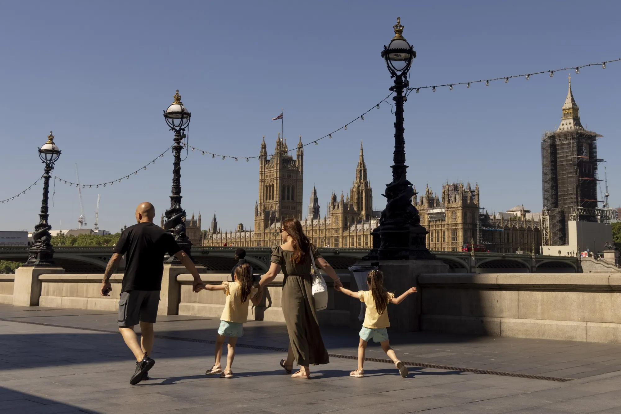 Pedestrians walk along the River Thames in London.